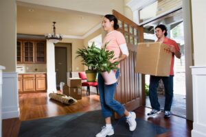 a man and a girl moving plants and carton inside the house | AHI Residential Home Inspection | Door Charlotte