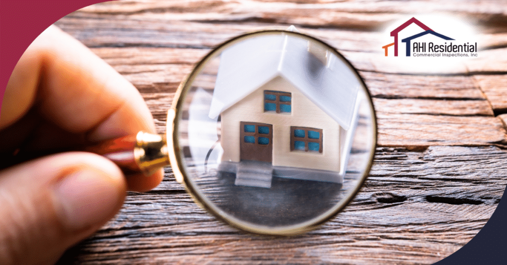 A close-up image of a hand holding a magnifying glass over a small house model