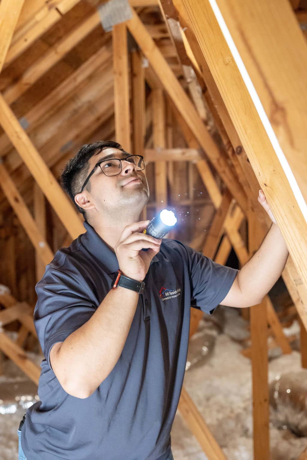a home inspector in the attic of a new construction home looking at truss installation