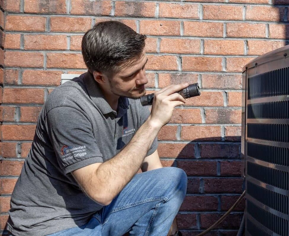 Home inspector looking at outside component of the HVAC system