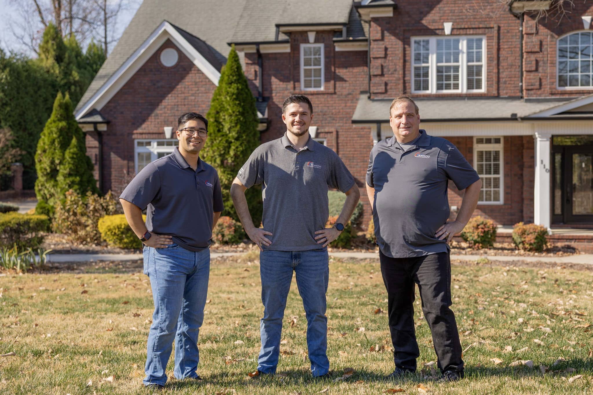 ahi team posing for a group photo outside the front of a home