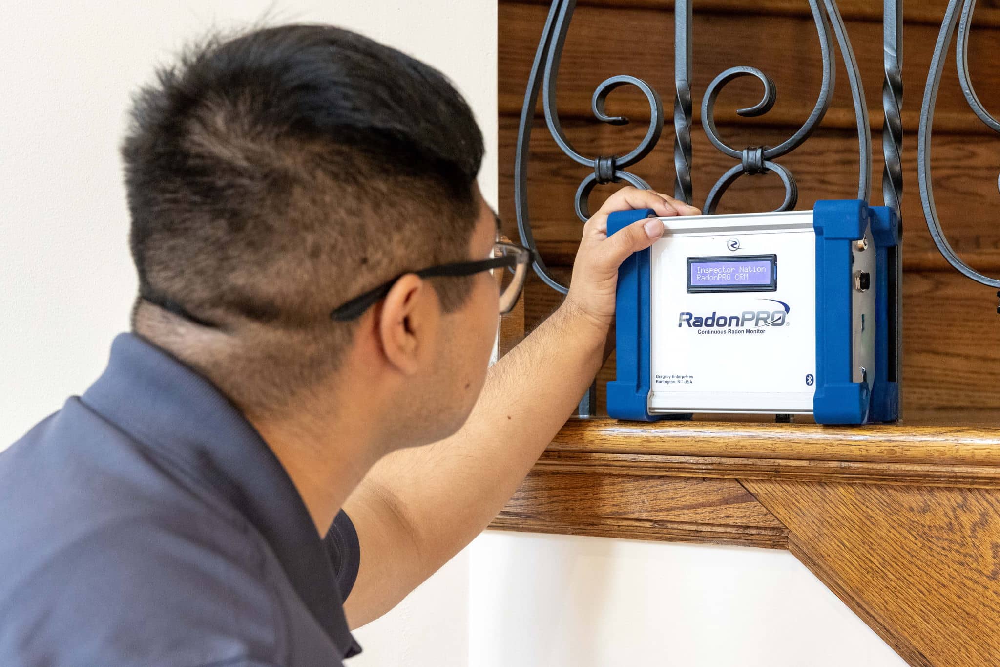 inspector setting up a radon gas test inside a home using a continuous radon monitor