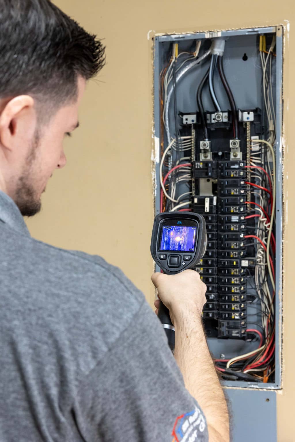 a home inspector using a thermal imaging camera to inspect the electrical panel