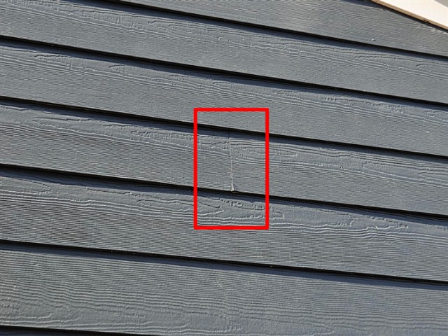 Cracked fiber cement siding board on Home D