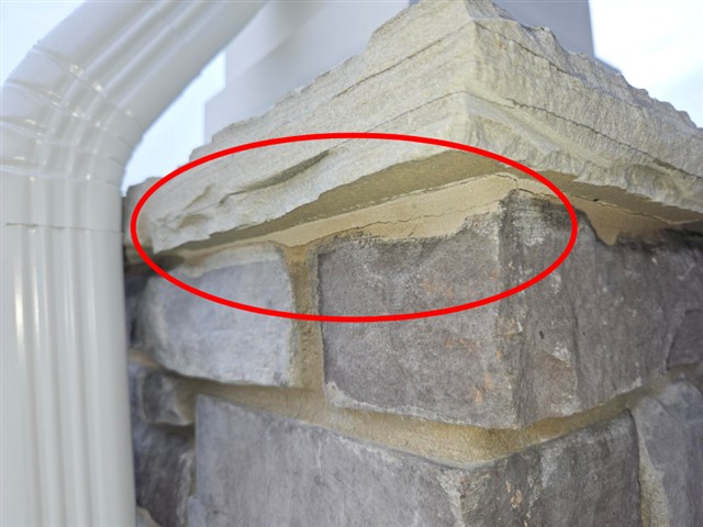 Cracked and missing mortar at the stone veneer cap on Home B