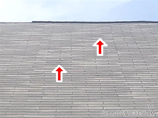 Poorly bonded, lifted shingles on the rear roof of Home J