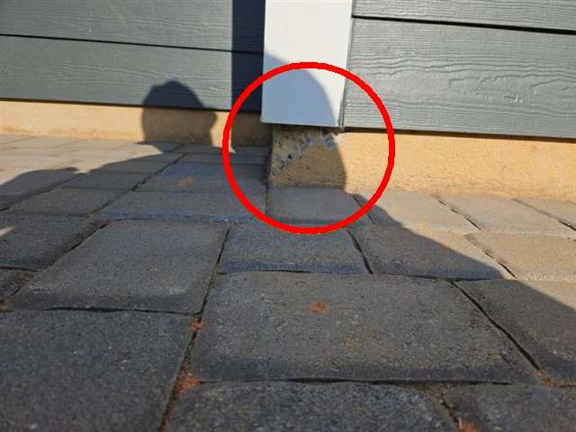 Void in the concrete foundation below the siding at the rear of Home D