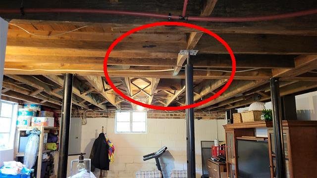 Home H: the basement floor system is deflecting and bowing, with added supports under it