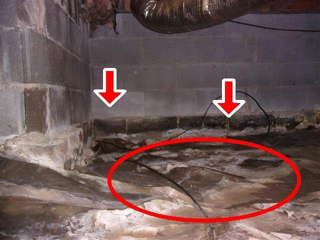 Home J: water stains on the block foundation and silt on the vapor barrier