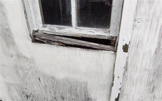Home C: rotted plywood siding at the rear of the home