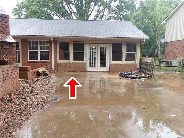 Home G: the rear drive slopes toward the house, sending water under the home