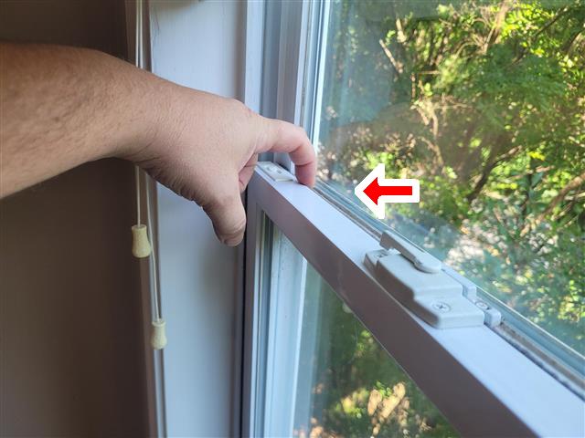 Inspector testing the tilt latch on a double-hung window sash
